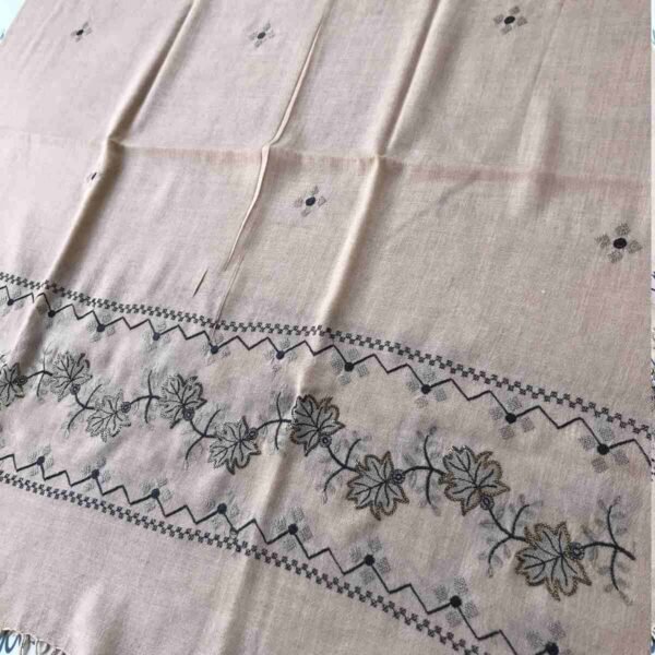 Light cream colored shawl with intricate black machine embroidery, offering warmth and elegance for winter wear