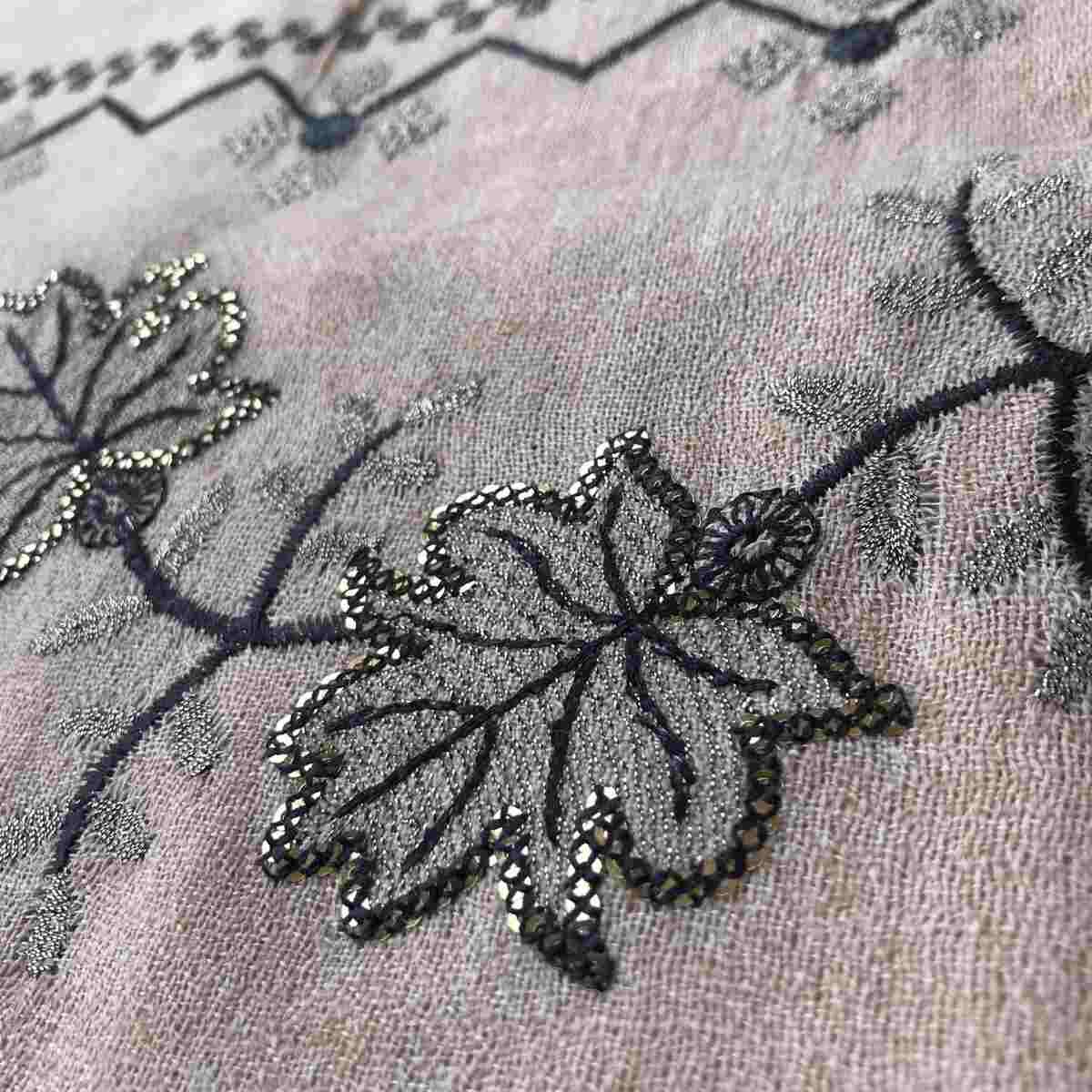 Light cream colored shawl with intricate black machine embroidery, offering warmth and elegance for winter wear