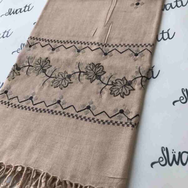 Light cream colored shawl with intricate black machine embroidery, offering warmth and elegance for winter wear